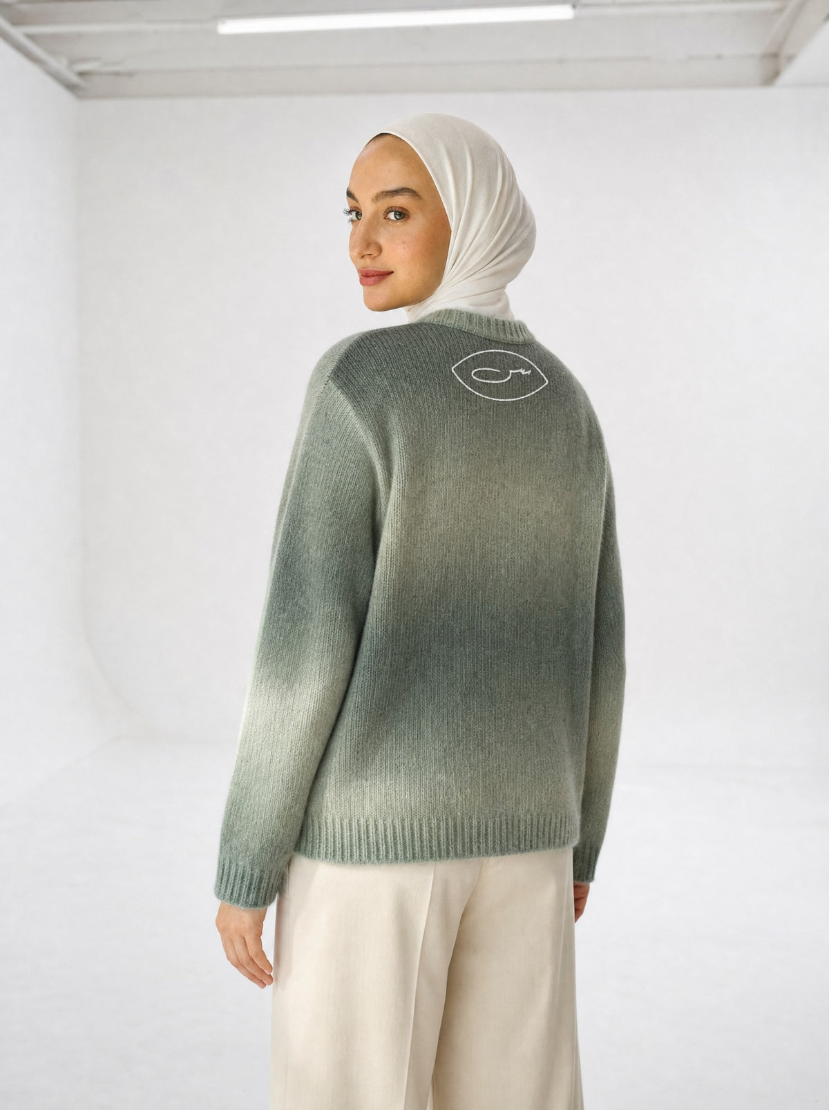 حرا Strickpullover getragen, Rückansicht mit SYRVAIN-Zeichen