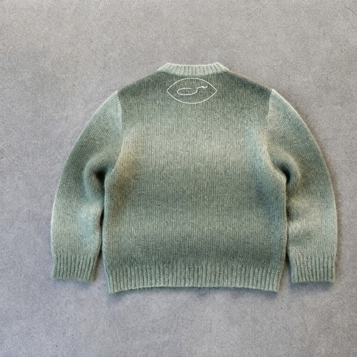 حرا Strickpullover, Rückseite mit gesticktem SYRVAIN-Zeichen unter dem Kragen