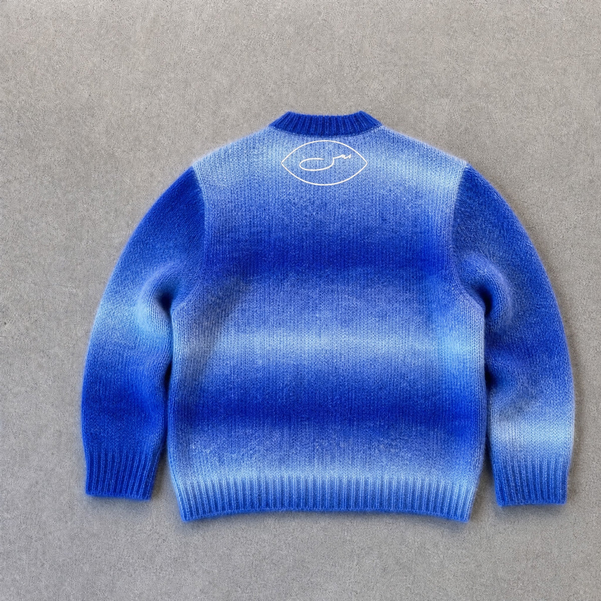 Strickpullover حرا in Blau, Rückseite mit SYRVAIN-Zeichen