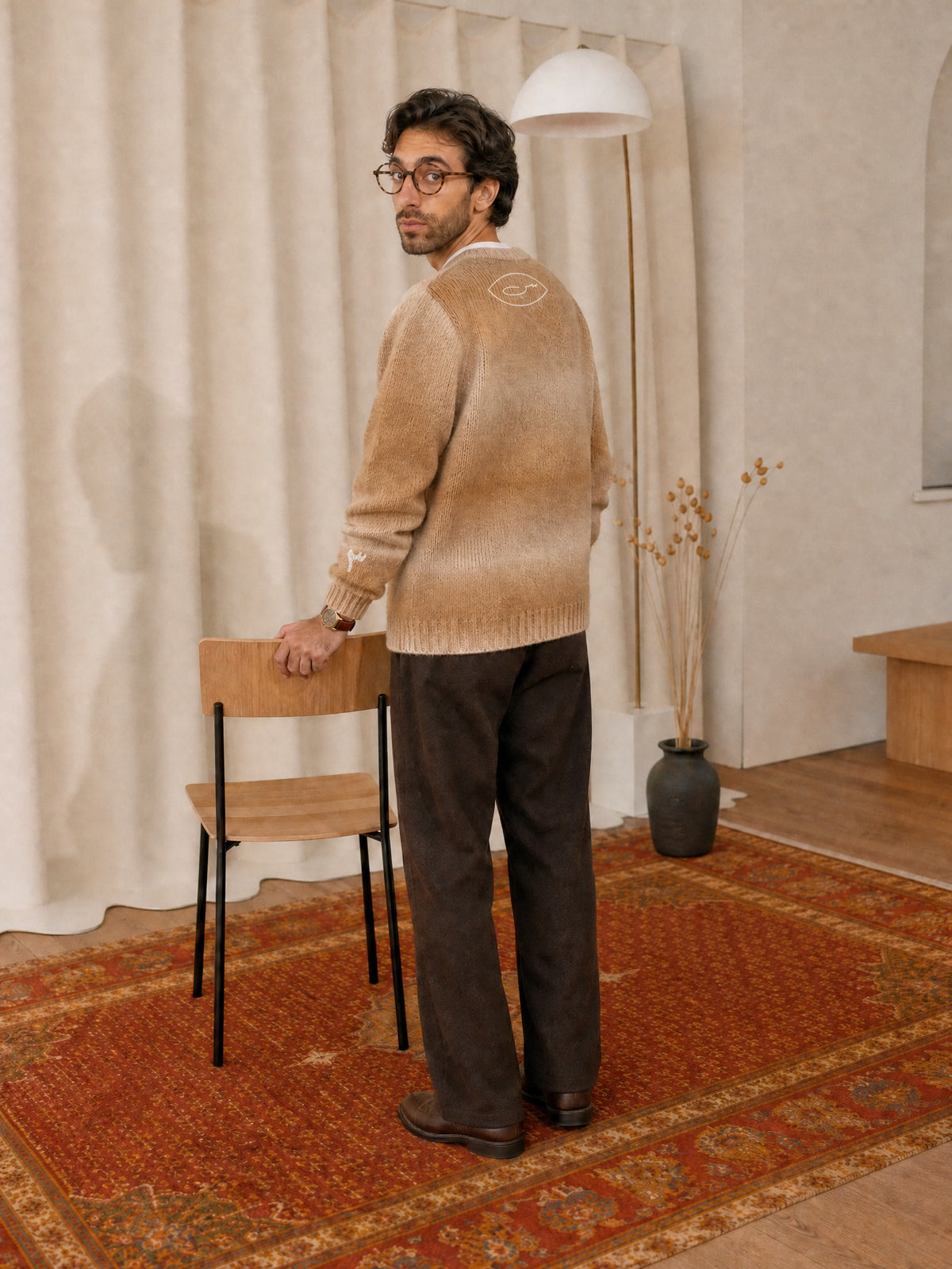 Ahmad im SYRVAIN «حرا» Strickpullover Khaki im Studio, Rückseite mit س-Symbol